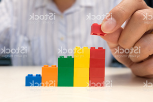 Businessman hand placing red plastic block on the top of stair. Business growth concept